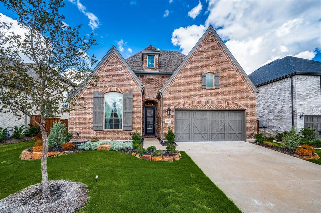 a front view of a house with a garden and yard