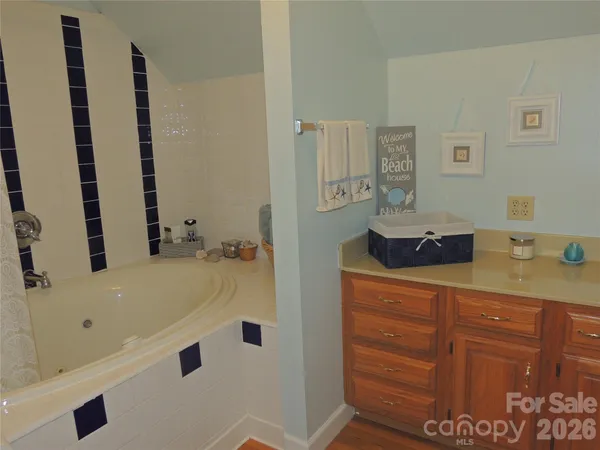 a bathroom with a tub sink and mirror