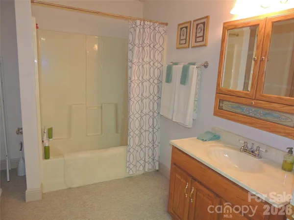 a bathroom with a granite countertop sink a mirror and shower