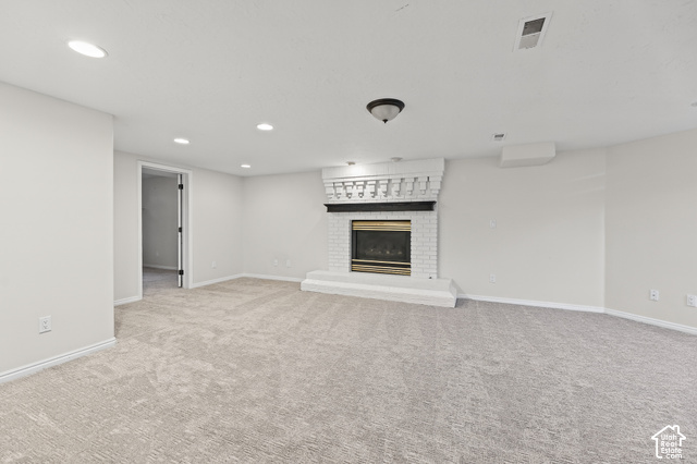 10664 Trail Ridge Circle Sandy, UT 84092 - Photo 41 of 113 Spacious carpeted room featuring a white brick fireplace with a black mantel, recessed lighting, and a neutral color palette