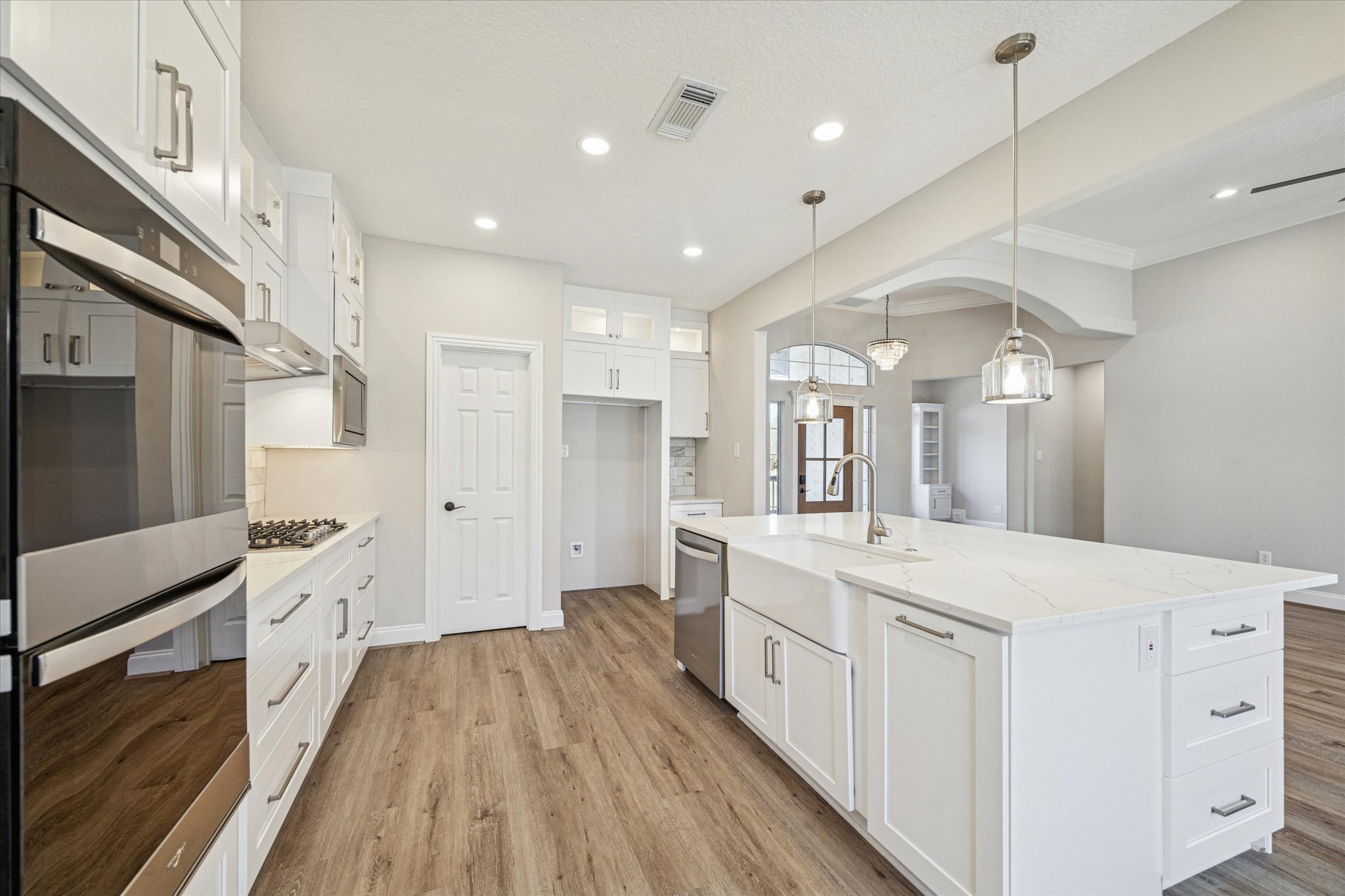 5437 Edgewater Court Willis, TX 77318 - Photo 11 of 29 a large white kitchen with a large center island wooden floor and stainless steel appliances