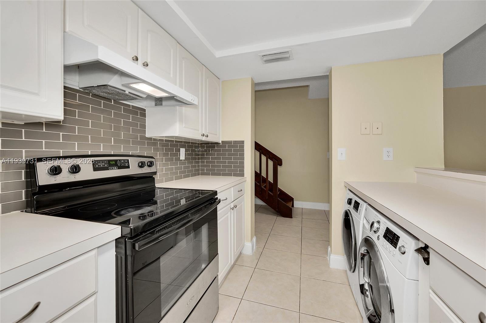 9079 Southwest 133rd Court, Unit F Miami, FL 33186 - Photo 12 of 34 a kitchen with a stove and a microwave
