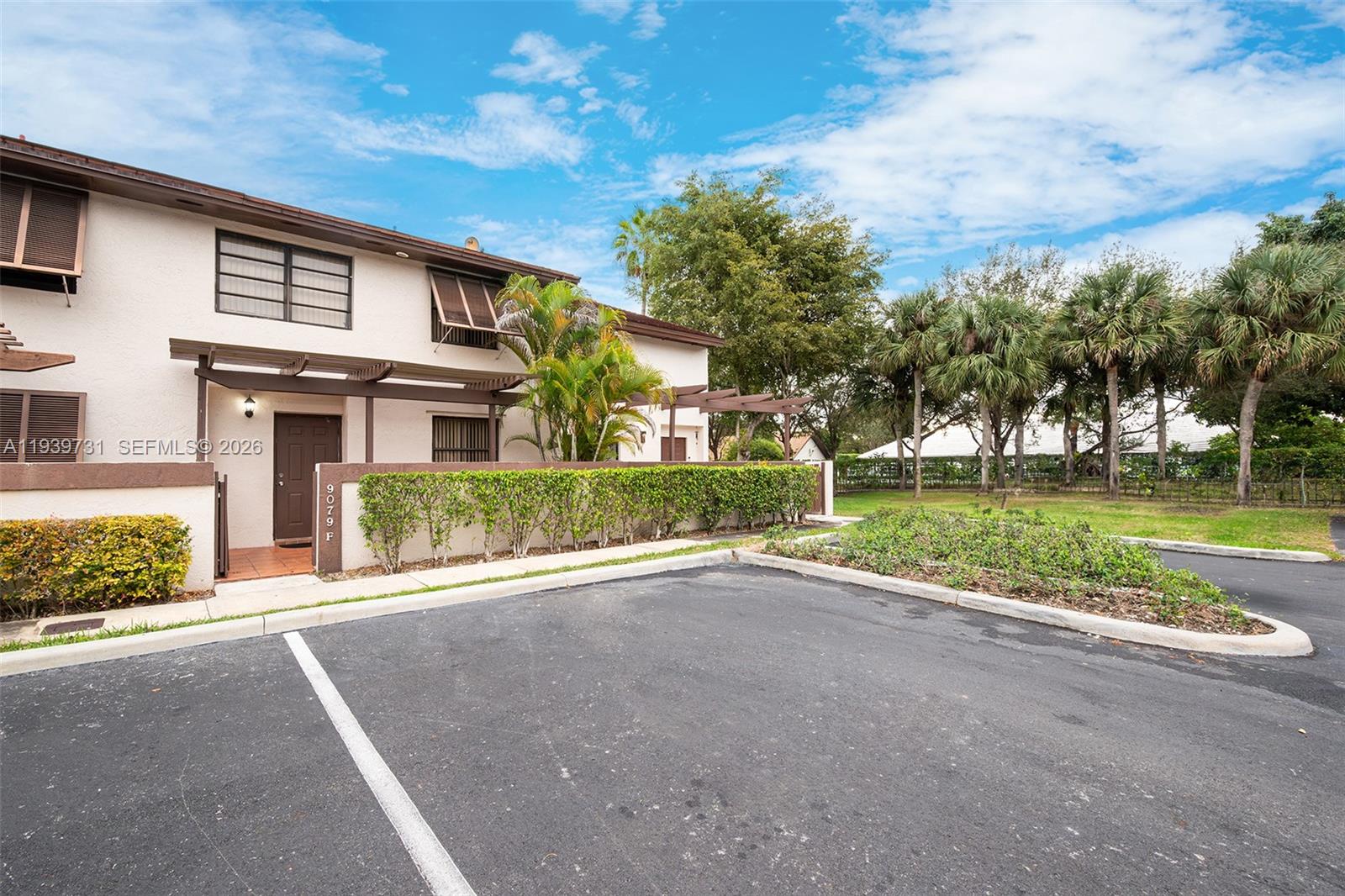 9079 Southwest 133rd Court, Unit F Miami, FL 33186 - Photo 2 of 34 a view of a house with a big yard and potted plants
