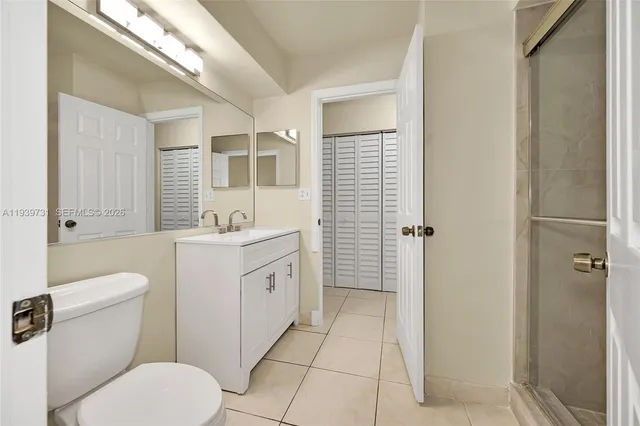 a bathroom with a toilet sink vanity and mirror