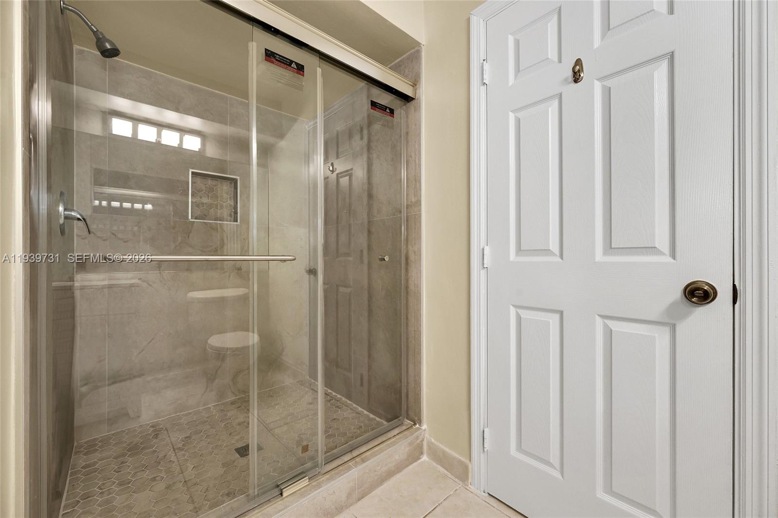 9079 Southwest 133rd Court, Unit F Miami, FL 33186 - Photo 25 of 34 a bathroom with a glass shower door