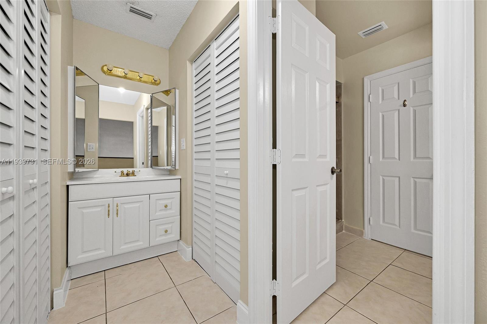 9079 Southwest 133rd Court, Unit F Miami, FL 33186 - Photo 26 of 34 a bathroom with a sink and a mirror