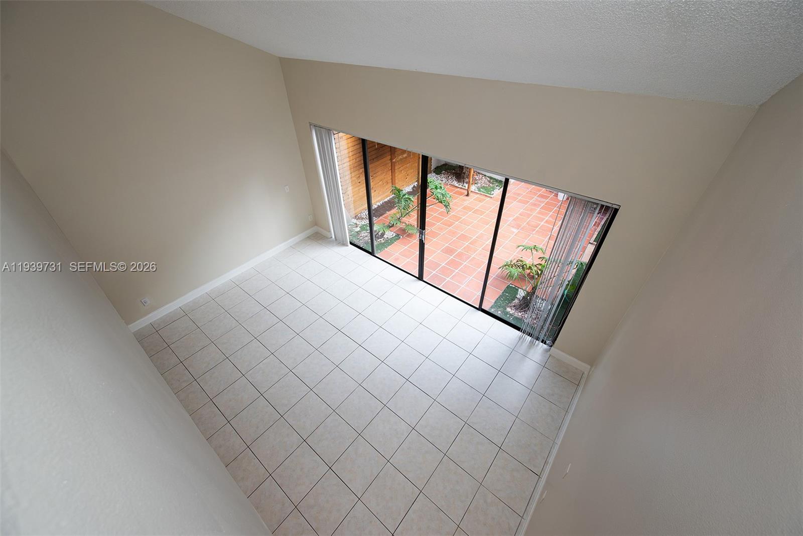 9079 Southwest 133rd Court, Unit F Miami, FL 33186 - Photo 30 of 34 a view of an empty room and window