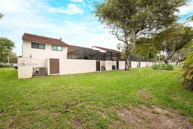 a sign of golf club on a wall under a tree