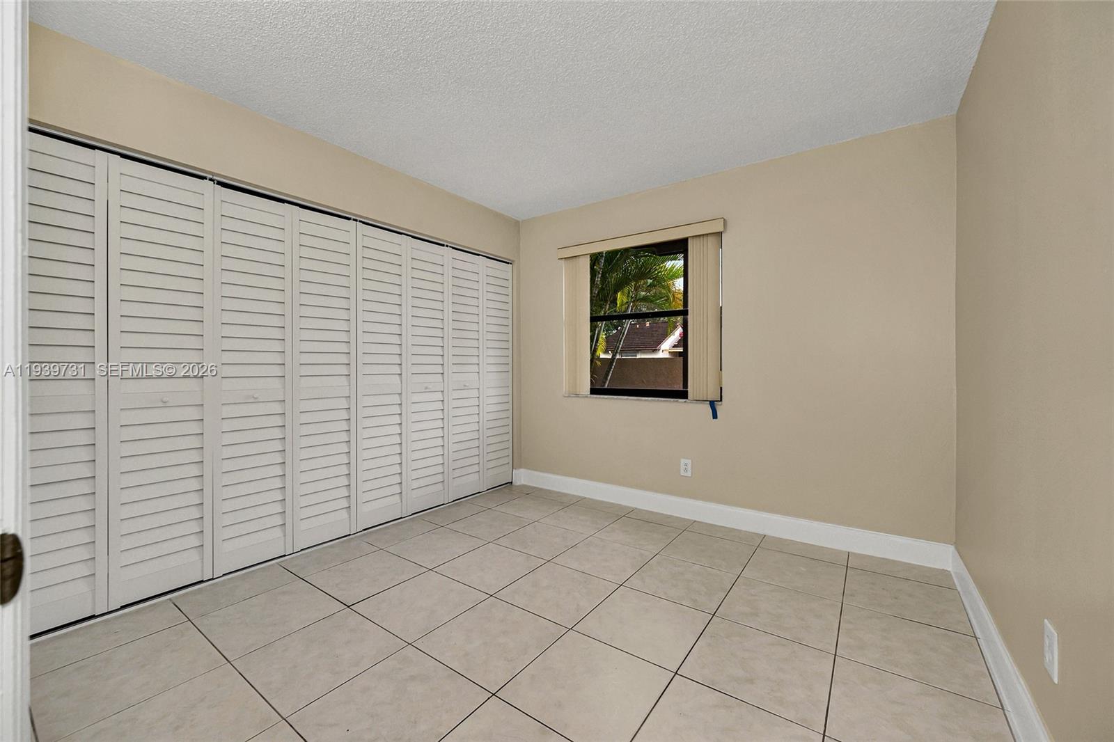 9079 Southwest 133rd Court, Unit F Miami, FL 33186 - Photo 8 of 34 a view of an empty room and window