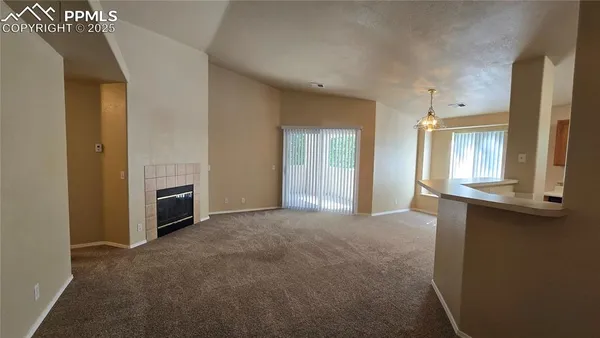 a view of an empty room with a fireplace and a window