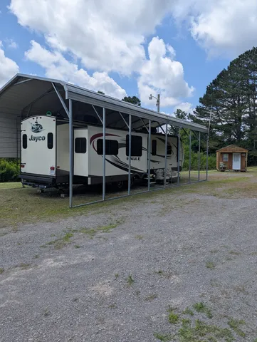a view of a house with a yard and wooden fence