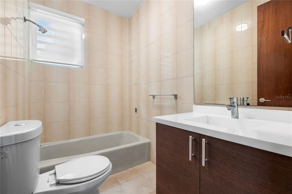 1 Street, Unit 606 Guaynabo, PR 00966 - Photo 14 of 32 a bathroom with a sink a toilet a mirror and shower