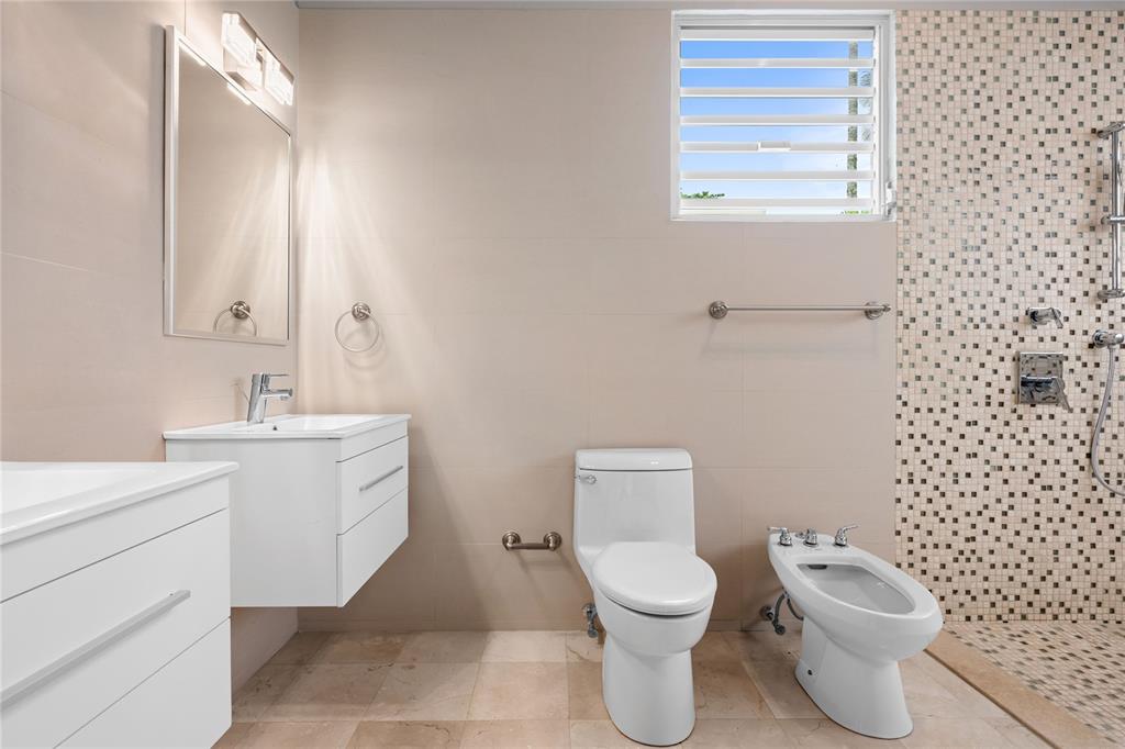 1 Street, Unit 606 Guaynabo, PR 00966 - Photo 28 of 32 a bathroom with a toilet sink vanity and mirror