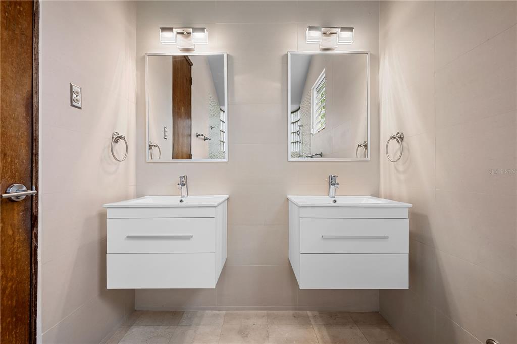 1 Street, Unit 606 Guaynabo, PR 00966 - Photo 29 of 32 a bathroom with double vanity sink and mirror