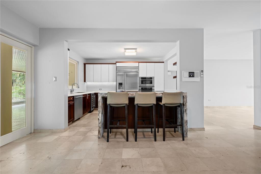 1 Street, Unit 606 Guaynabo, PR 00966 - Photo 9 of 32 a large white kitchen with a table and chairs