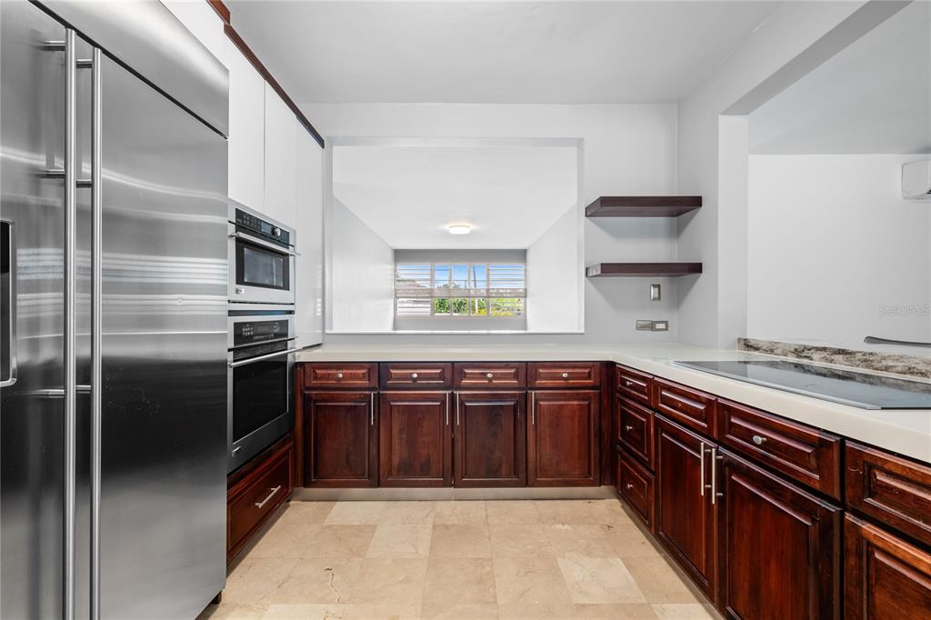 1 Street, Unit 606 Guaynabo, PR 00966 - Photo 10 of 32 a kitchen with stainless steel appliances granite countertop a refrigerator and a sink