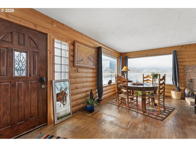 a dining room with furniture and a floor to ceiling window
