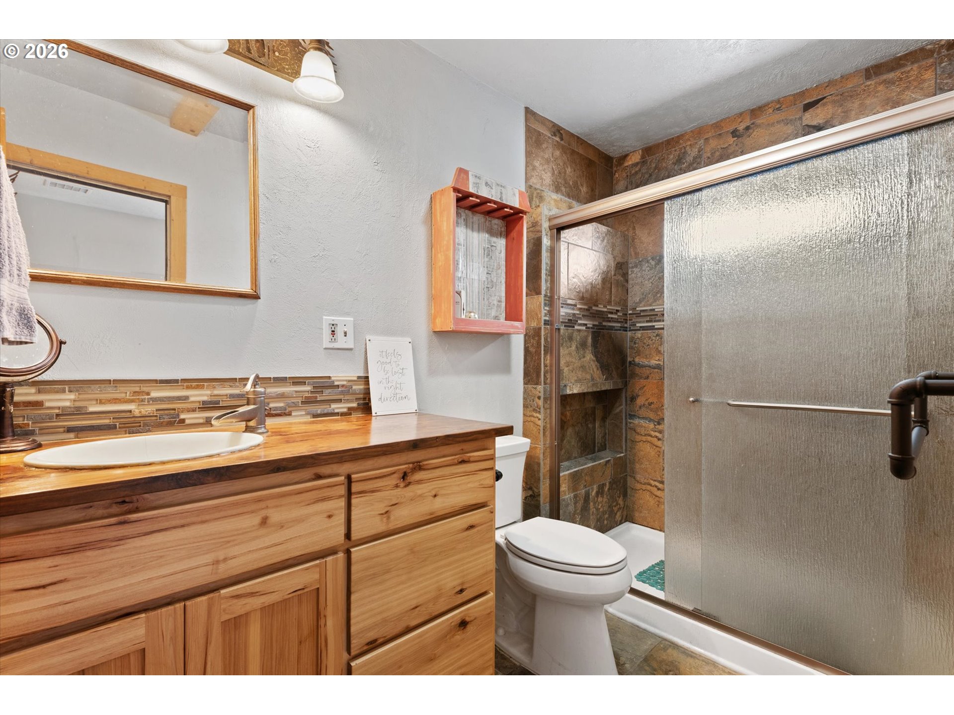 46278 Pocahontas Road Haines, OR 97833 - Photo 26 of 42 a bathroom with a granite countertop sink toilet a mirror and shower