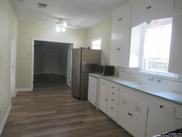 a kitchen with granite countertop white cabinets and stainless steel appliances