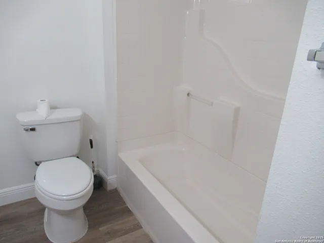 a white toilet sitting next to a bath tub