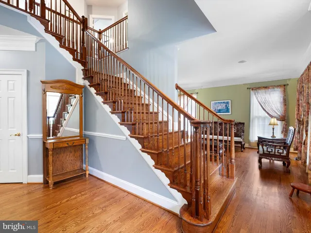 a living room with furniture and wooden floor next to a window