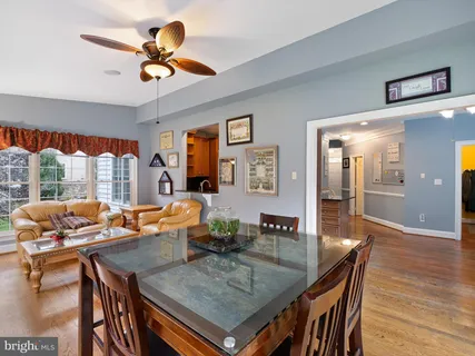 a dining room with furniture a chandelier and wooden floor