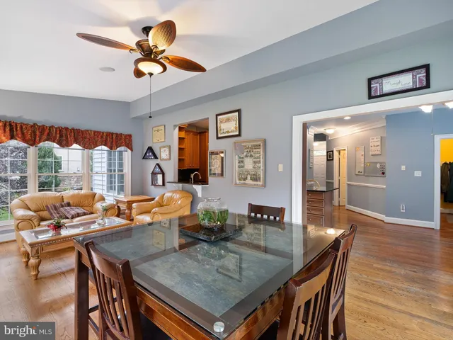 a dining room with furniture a chandelier and wooden floor