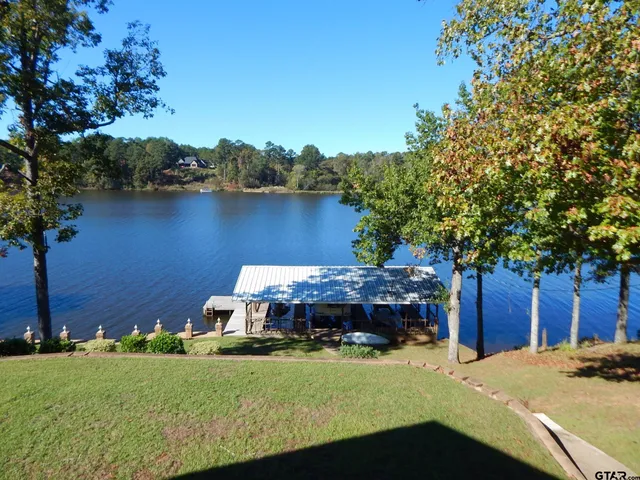 a view of a swimming pool with lawn chairs under an umbrella