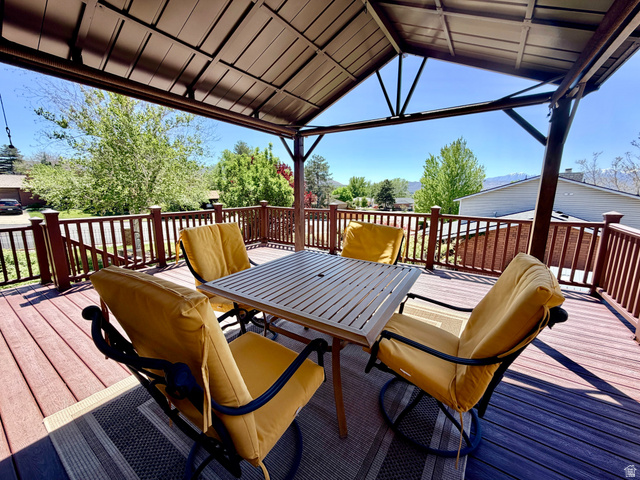 12080 Mill Ridge Circle Sandy, UT 84094 - Photo 34 of 56 Covered outdoor deck with composite decking, brown railing, and an overhead canopy structure