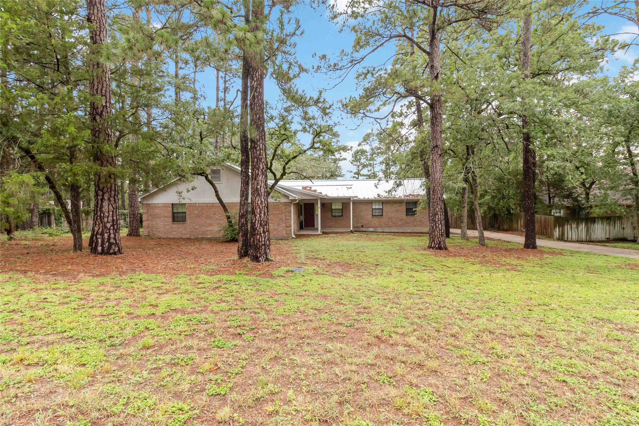 326 Pine View Loop Bastrop, TX 78602 - Photo 10 of 30 Mature trees frame this brick home, offering a tranquil retreat with ample privacy and natural beauty.
