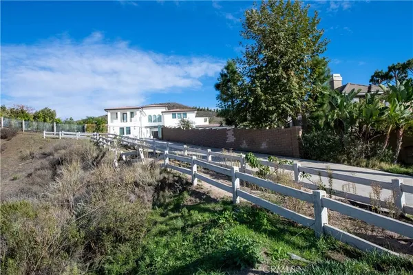 a view of a swimming pool with a yard and large trees