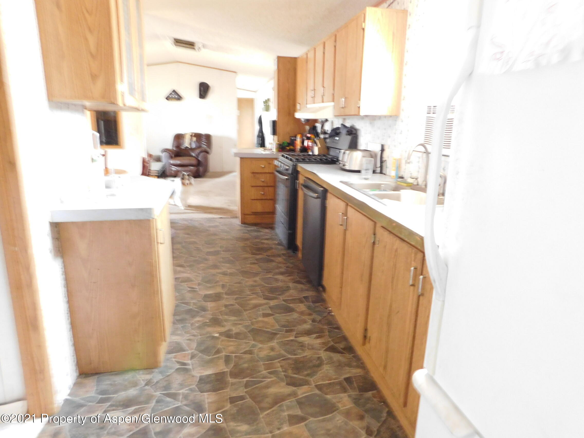 2210 West 3rd Street, Unit 28 Craig, CO 81625 - Photo 9 of 12 a kitchen with kitchen island granite countertop a sink appliances cabinets and a counter top space