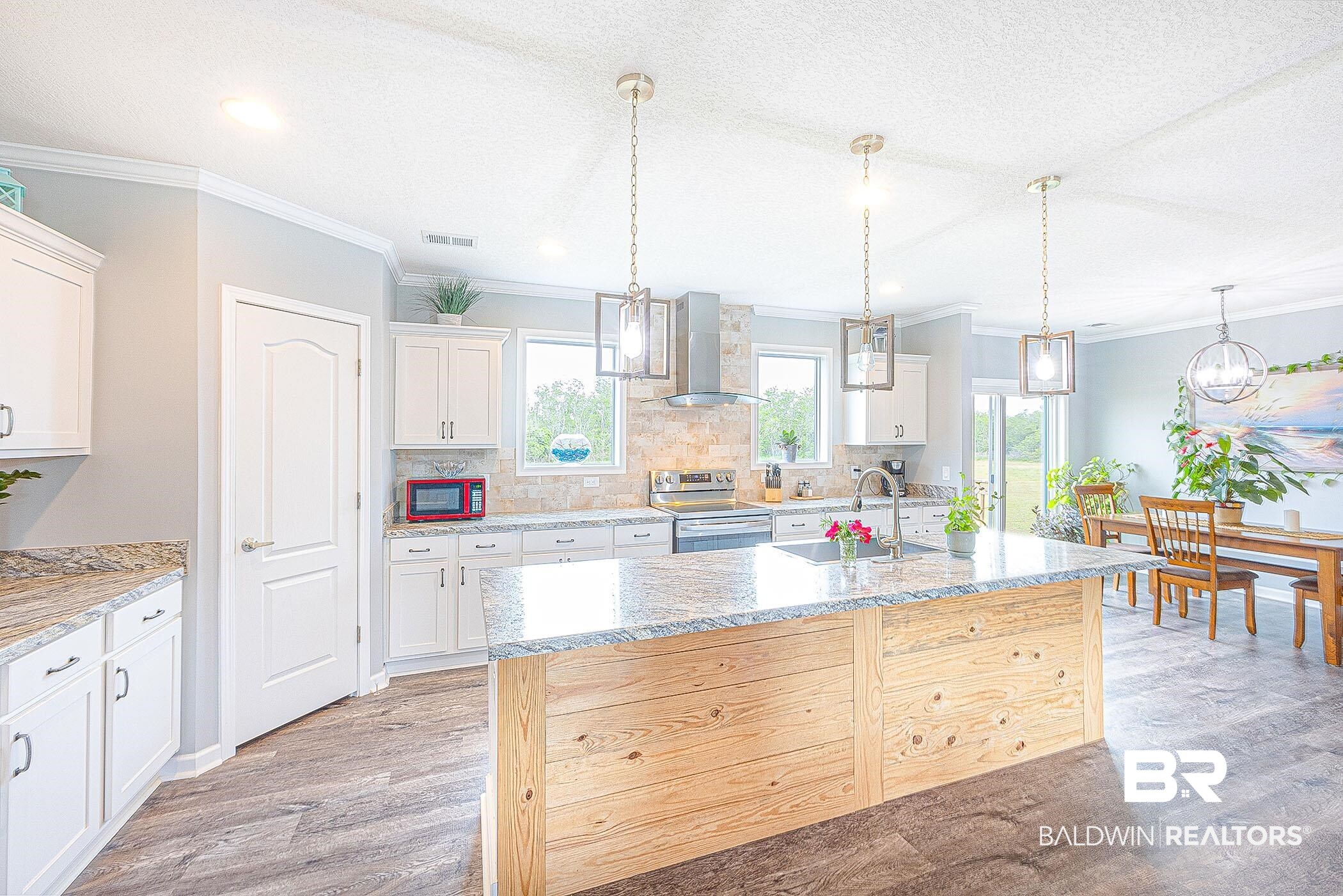 16000 John Bauer Road Summerdale, AL 36580 - Photo 13 of 34 Kitchen with light wood-style flooring, white cabinetry, an island with sink, stainless steel range with electric stovetop, and wall chimney exhaust hood