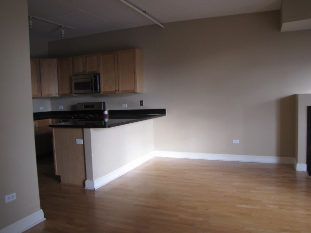 1001 West Madison Street, Unit 501 Chicago, IL 60607 - Photo 5 of 15 a kitchen with stainless steel appliances a sink a stove a microwave a counter top space and cabinets