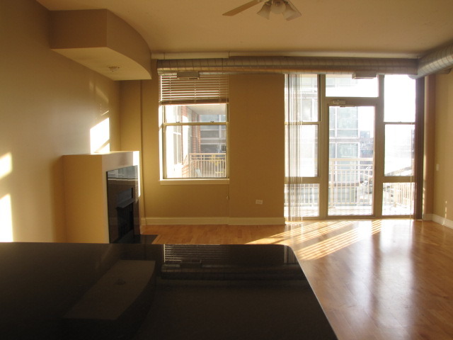 1001 West Madison Street, Unit 501 Chicago, IL 60607 - Photo 10 of 15 a view of an empty room with wooden floor and a window