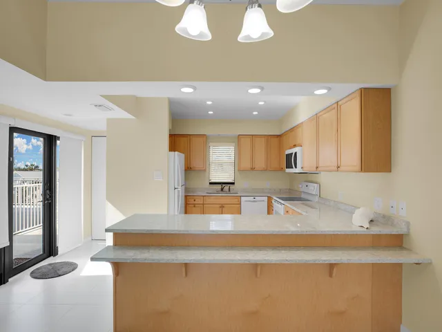 a kitchen with kitchen island granite countertop a sink a counter top space and cabinets