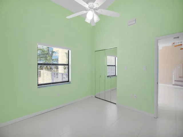 an empty room with windows and fan