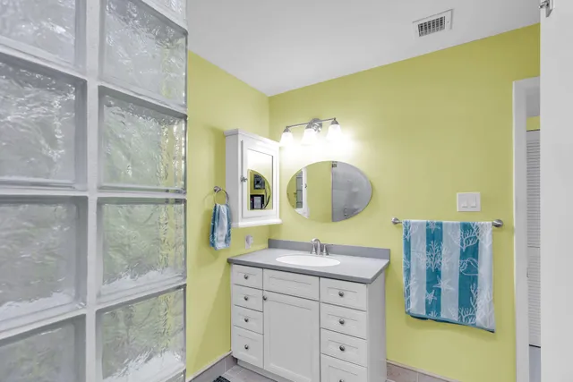 a bathroom with a granite countertop sink mirror and vanity