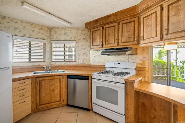 a kitchen with cabinets appliances a sink and a window