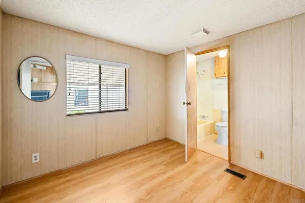 an empty room with wooden floor and a window