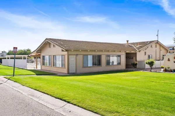 a view of a house with a yard and sitting area