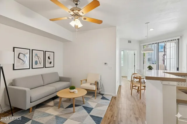 a living room with furniture a ceiling fan and a rug