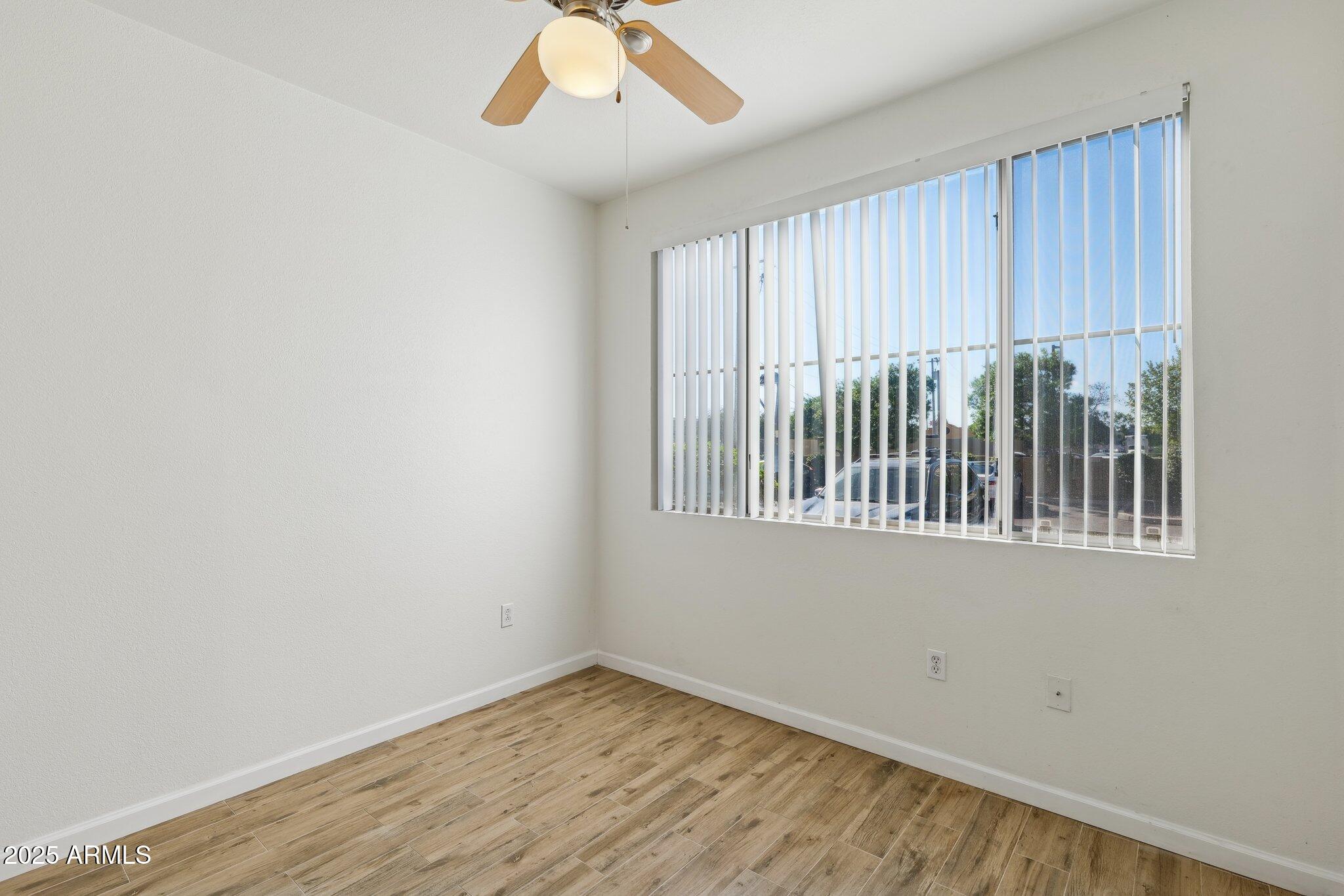1701 East Colter Street, Unit 182 Phoenix, AZ 85016 - Photo 15 of 55 an empty room with wooden floor and windows