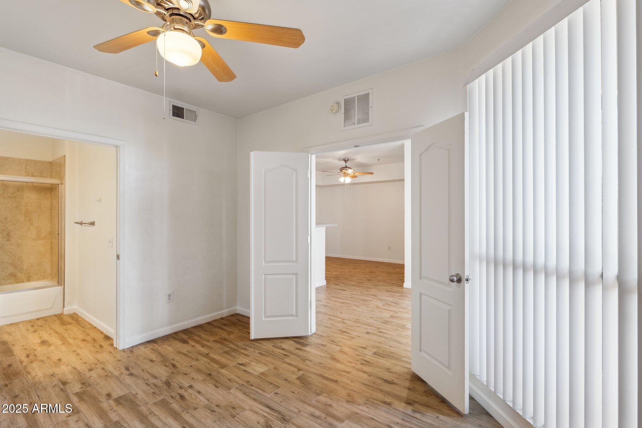 1701 East Colter Street, Unit 182 Phoenix, AZ 85016 - Photo 19 of 55 a view of an empty room with wooden floor and a ceiling fan