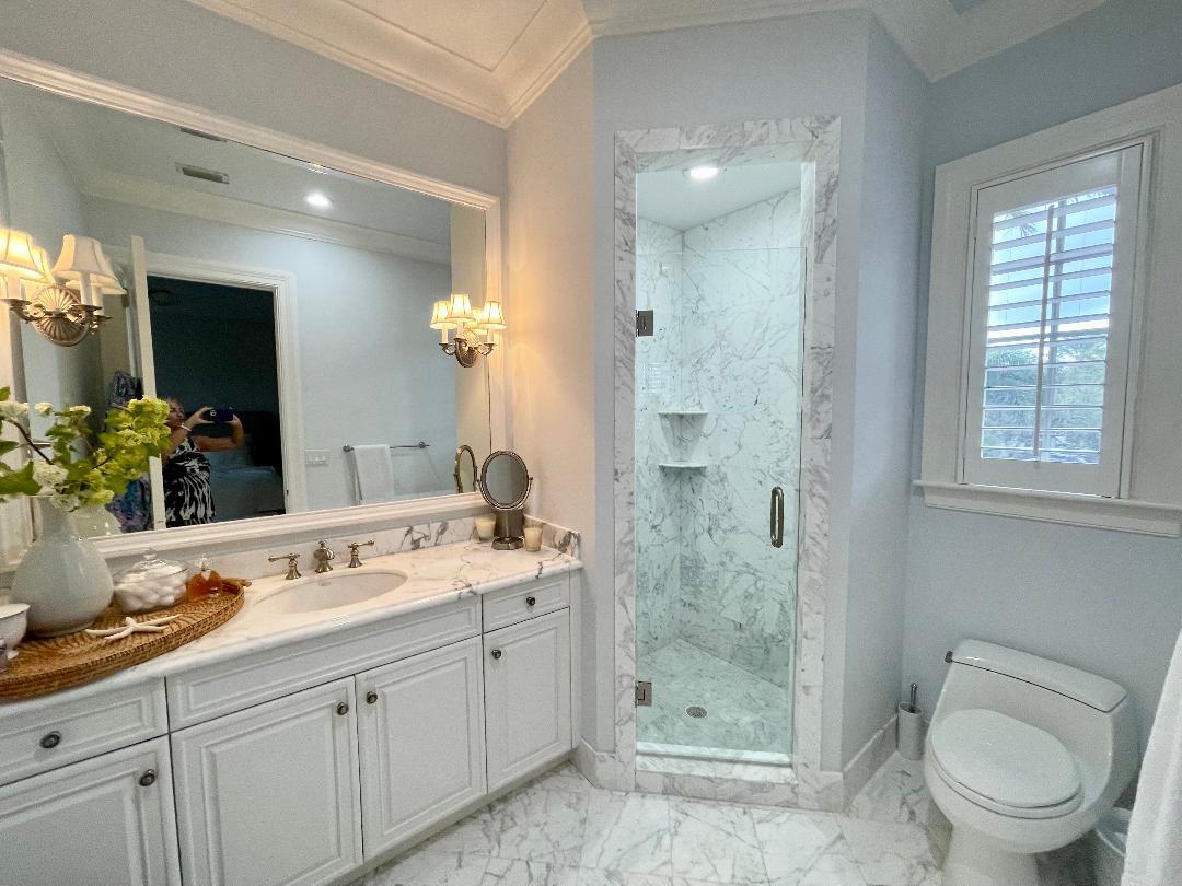503 Bald Eagle Drive Jupiter, FL 33477 - Photo 27 of 62 a spacious bathroom with a granite countertop sink toilet a large mirror a shower and a window