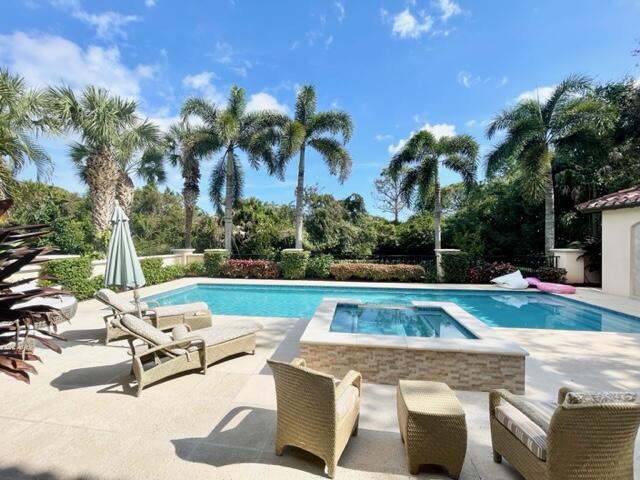 503 Bald Eagle Drive Jupiter, FL 33477 - Photo 30 of 62 a view of a swimming pool with lounge chairs
