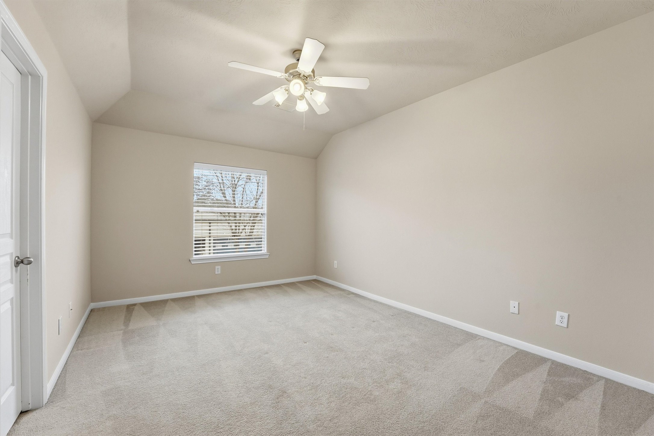 17415 Memorial Mills Drive Spring, TX 77379 - Photo 25 of 37 Upstairs bedroom with en-suite featuring vaulted ceilings, plush carpet, and a ceiling fan with light.