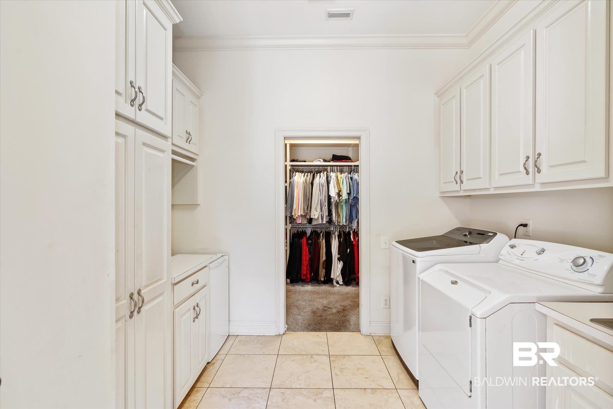 3963 Wimbledon Park Mobile, AL 36608 - Photo 29 of 51 Washroom featuring crown molding, light tile patterned floors, cabinets, and washing machine and clothes dryer