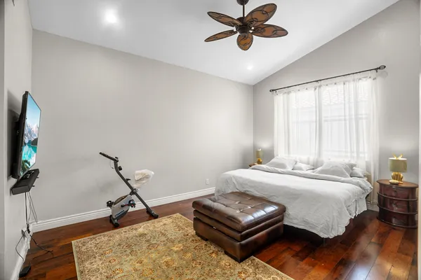 a bedroom with a bed a chandelier and a window