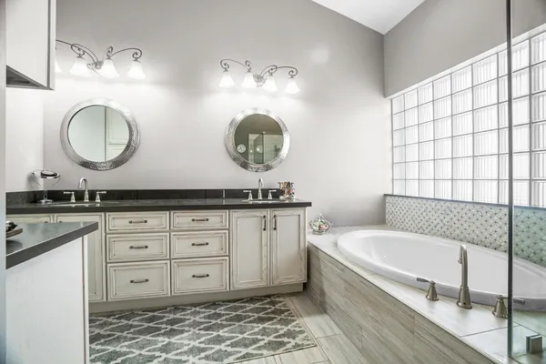 a bathroom with a tub sink and mirror